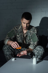 Poster - Soldier with ptsd holding antidepressants at home at night.