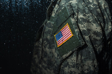 Poster - cropped view of American serviceman in military uniform with flag standing behind rainy window.