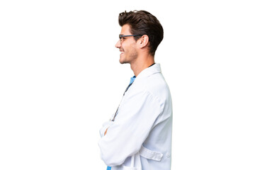 Wall Mural - Young doctor man over isolated background in lateral position