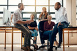 © Nola V/peopleimages.com - Their collaborative culture keeps them productive. a group of businesspeople having a discussion in a modern office.