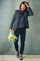 Wall Mural - Ive got someone to see. Studio shot of a stylishly dressed handsome young man smiling and holding a bouquet of flowers.