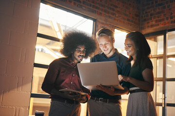 Wall Mural - Technology makes it easier to keep everything up to date. a group of designers working together on a laptop.