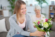 © auremar - young daughter and mother with bouquet of flowers at home