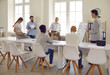 © Studio Romantic - Team listens report of employee, which shows statistics of company in form of tables and graphs on whiteboard. Boss invites employees of department to express opinion on success of planned project.