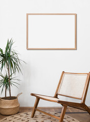 Empty horizontal frame mockup in modern minimalist interior with plant in trendy vase on white wall background. Template for artwork, painting, photo or poster