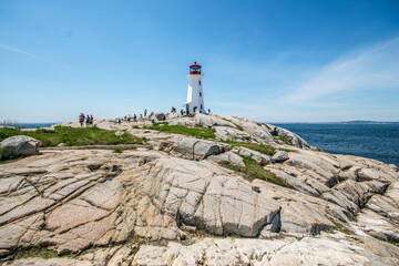 Lighthouse by sea against sky in Peggy's Cove, Nova Scotia.