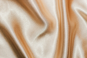 Wall Mural - Golden shiny texture of silk satin satin with folds.