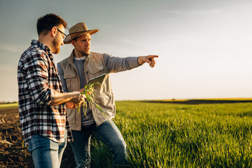 Two men standing in the field.