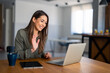 © Dorde - Kind smiling businesswoman, satisfied female entrepreneur waving hand looking at laptop during virtual video conference call in home office.