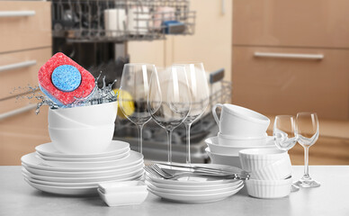 Poster - Many clean tableware in kitchen. Dishwasher detergent falling into bowl with water