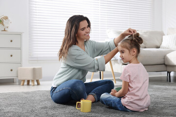 Wall Mural - Young mother and her daughter spending time together at home