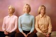© Robert MEYNER - Three women meditating in lotus position on a pink background.
