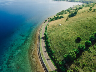 Aerial view of ocean coastline with shore road in Sumbawa