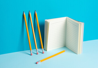 Wall Mural - Pencils and notebook on a blue background. Creative business layout