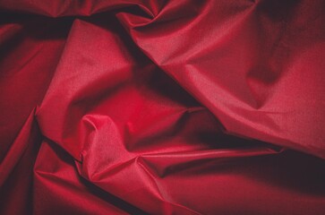 Red wrinkled fabric texture. Close-up of textile structure, may be used as background.