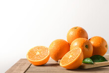 Fresh Oranges With Cut In Half On Wooden Table.