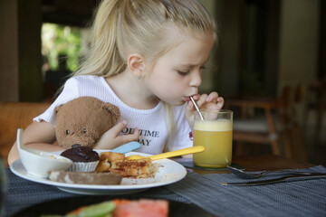 Cute 5 years old girl having kids meal at the restaurant