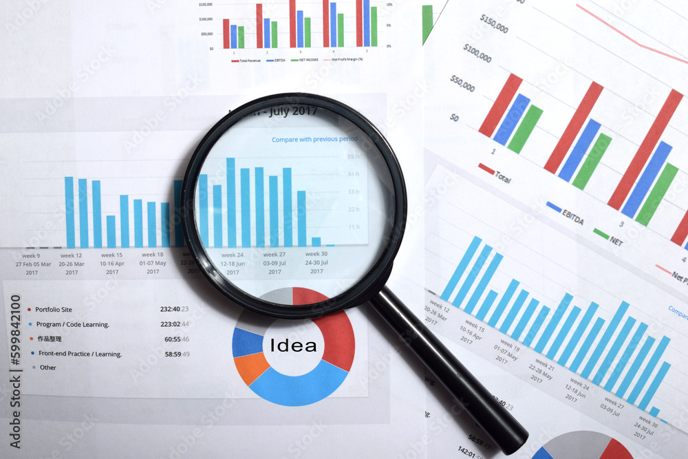 Magnifying glass on charts graphs paper. Financial development ...