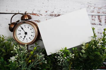 Wall Mural - Alarm clock with mockup paper card on wooden background