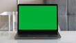 © DomenicoFornas - A Green Screen Laptop on a White Table at Home