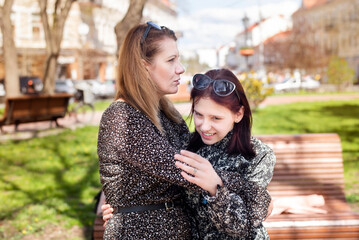 A middle-aged woman hugs her teenage daughter and gives her encouraging, uplifting words. A teenage girl is talking to her mother