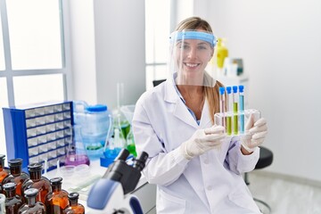 Sticker - Beautiful woman working at scientist laboratory looking positive and happy standing and smiling with a confident smile showing teeth