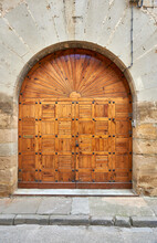 Entrance With A Semicircular Arch With A Wooden Door In A Grid With Wooden Slats And A Tympanum In The Shape Of A Radiant Sun In Fine Carpentry With Decorative Nails, Knob And Lock,