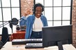 Beautiful black woman playing piano at music studio doing ok sign with fingers, smiling friendly gesturing excellent symbol