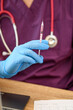 Lekarz ze stetoskopem na szyi i strzykawką w rękach siedzący przy biurku