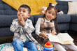 © Krakenimages.com - Adorable boy and girl reading book clapping hands at home
