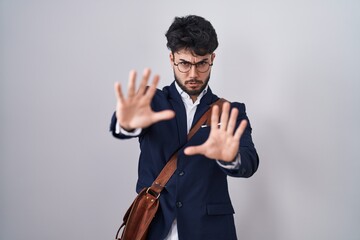 Sticker - Hispanic man with beard wearing business clothes afraid and terrified with fear expression stop gesture with hands, shouting in shock. panic concept.