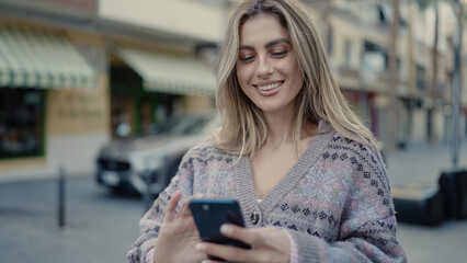 Poster - Young blonde woman smiling confident using smartphone at street