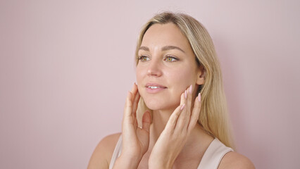 Poster - Young blonde woman smiling confident touching face over isolated pink background