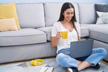 Canvas Print - Young hispanic woman using laptop drinking coffee at home