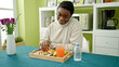 © Krakenimages.com - African american woman having breakfast sitting on table at dinning room