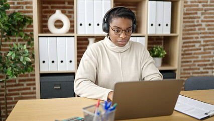 Poster - African american woman business worker using laptop and headphones working at office