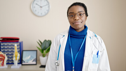 Canvas Print - African american woman doctor standing with serious expression at clinic