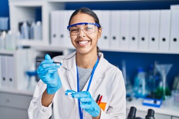 Sticker - Young african american woman scientist holding pills at laboratory