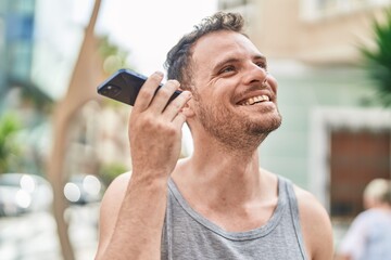 Poster - Young hispanic man smiling confident listening audio message by the smartphone at street