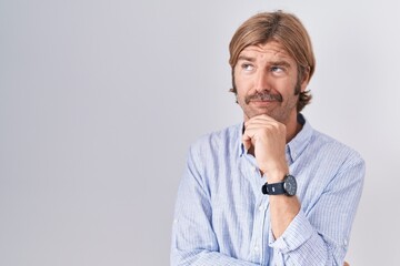 Poster - Caucasian man with mustache standing over white background thinking worried about a question, concerned and nervous with hand on chin