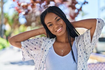 Sticker - African american woman smiling confident relaxed with hands on head at park