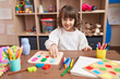 © Krakenimages.com - Adorable hispanic girl playing with maths puzzle game sitting on table at kindergarten