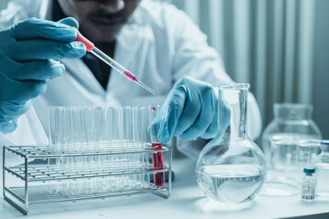 Scientist holding flask with lab glassware and chemistry laboratory test tubes Research and development in science laboratory, science technology concept
