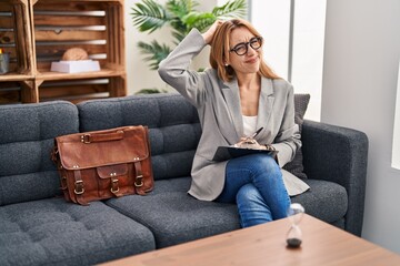 Wall Mural - Hispanic woman working at consultation office confuse and wondering about question. uncertain with doubt, thinking with hand on head. pensive concept.