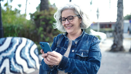 Poster - Middle age woman with grey hair using smartphone at park