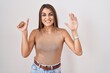 © Krakenimages.com - Young hispanic woman standing over white background showing and pointing up with fingers number six while smiling confident and happy.