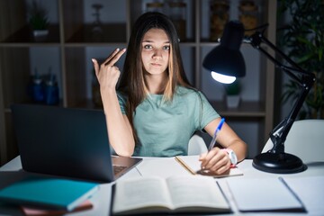 Canvas Print - Teenager girl doing homework at home late at night shooting and killing oneself pointing hand and fingers to head like gun, suicide gesture.