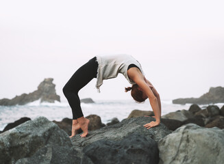 Wall Mural - Woman practicing yoga on the beach. Active Travel Healthy Yoga Lifestyle.