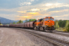 Freight Train With A Colorful Sunset In Background Near Whitefish, Montana