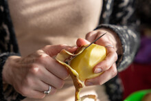 Close Up Of Women Holding And Peeling Potato With A Knife